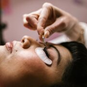 Close-up van een vrouw die in een beautysalon met een pincet wimperextensions laat plaatsen